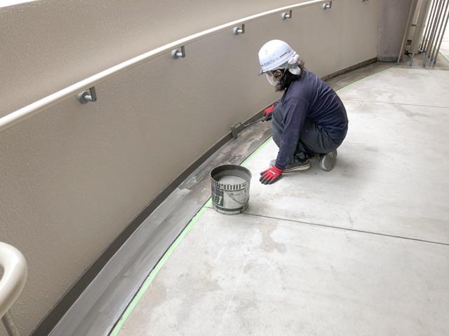 ベランダの防水工事をする職人